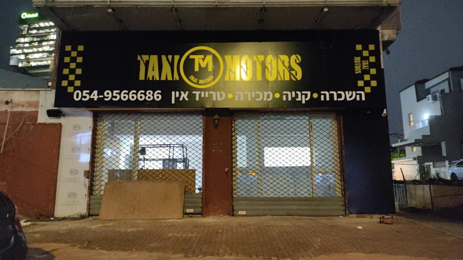 שילוט חזית עסק Taxi Motors בלילה
